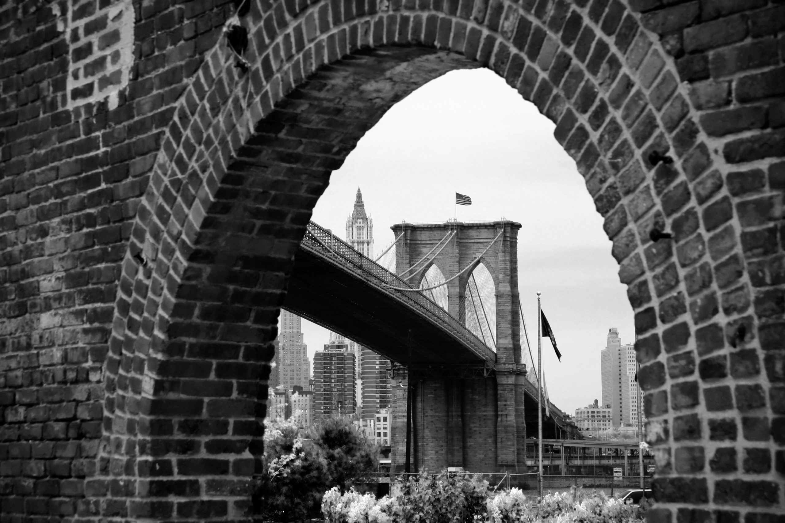 A view of the Brooklyn Bridge through a brick archway. The Dan Englander's Sales Schema is based out of Brooklyn, NY.
